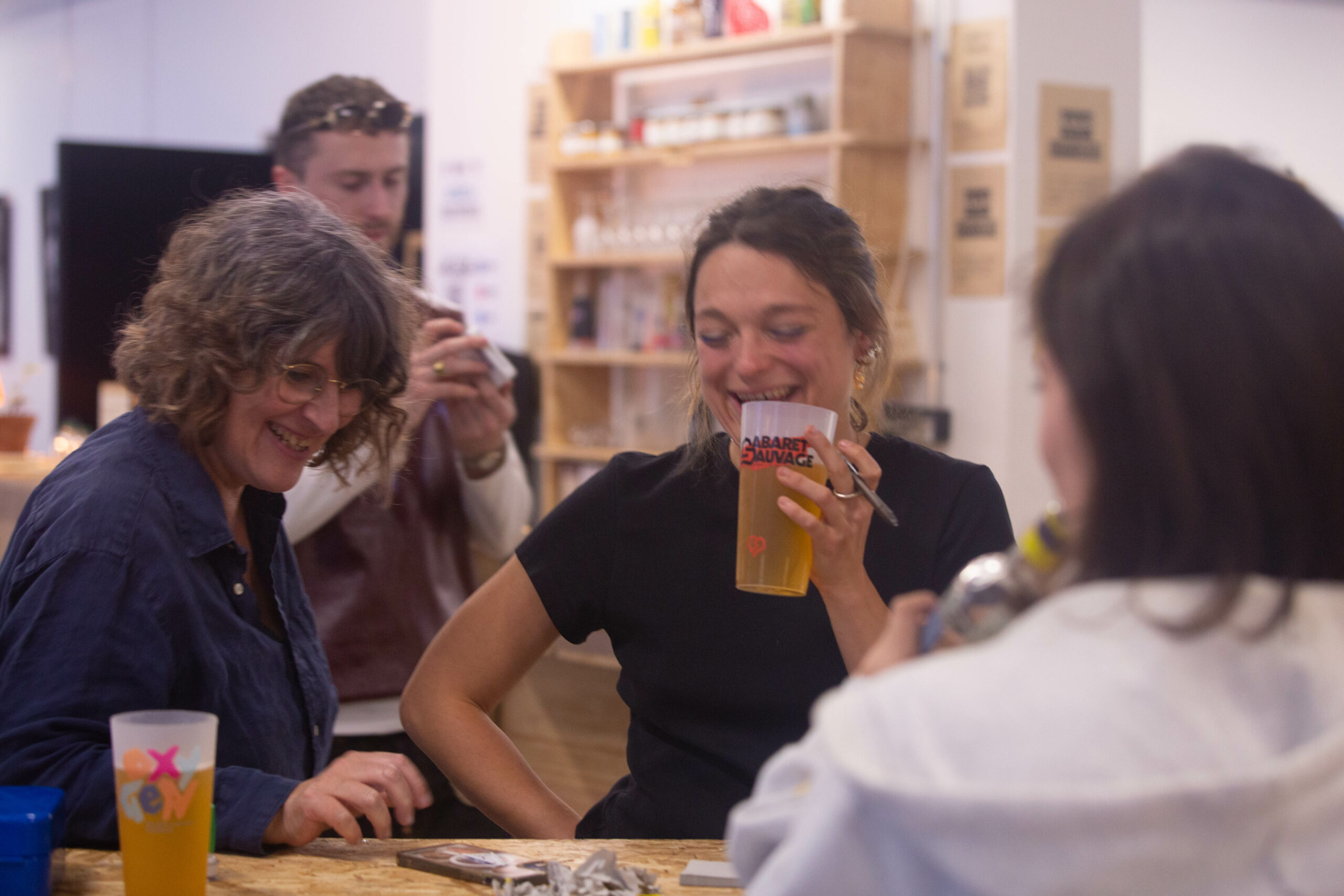 Plusieurs personnes rient et boivent au bar associatif de l'AGECA